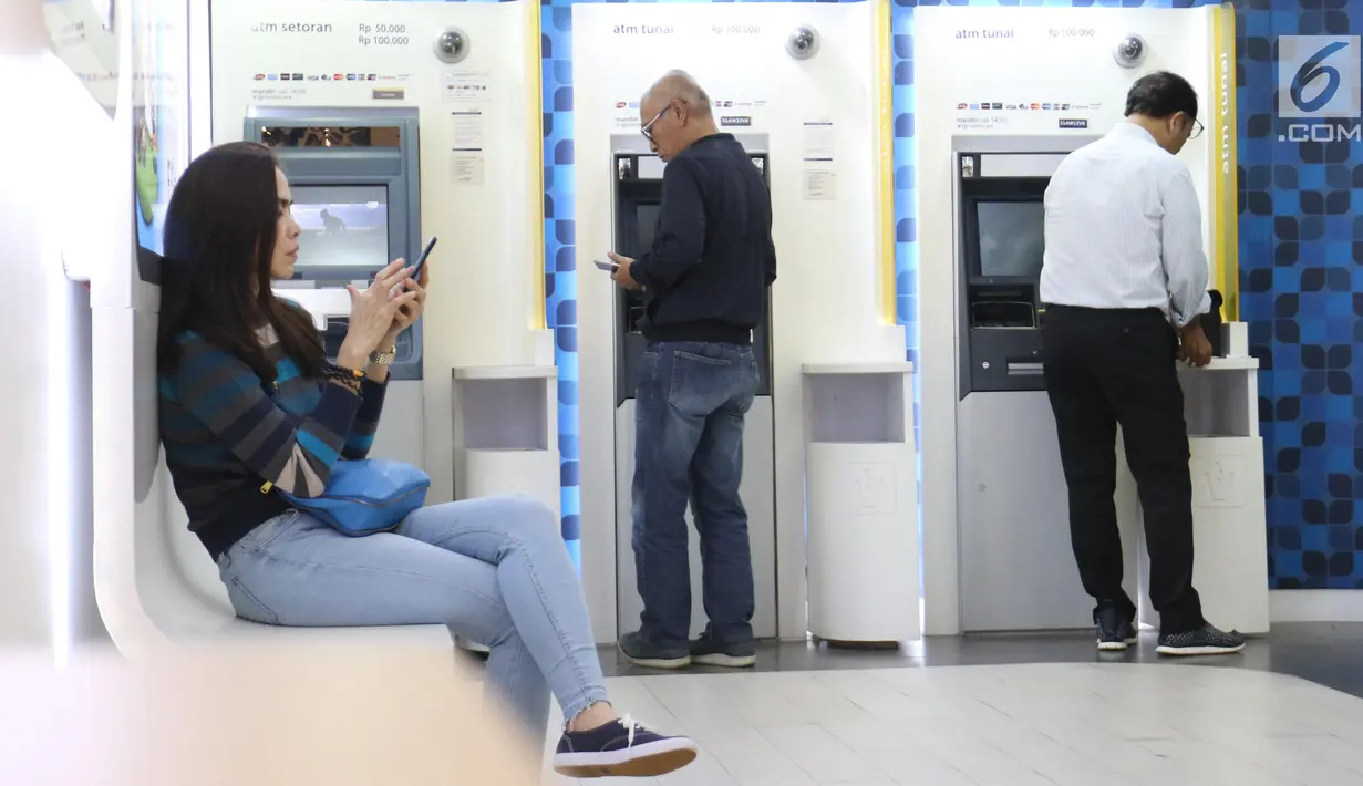 Pengunjung melakukan penarikan uang melalui ATM di kawasan Jakarta, Jumat (25/1). Sepanjang 2018, volume transaksi debit Mandiri tumbuh 6% secara year on year (yoy), sedangkan dari sisi nominalnya tumbuh 7% yoy. (Liputan6.com/Angga Yuniar)