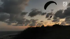 Wisatawan melakukan tandem paralayang di Bukit Riug, Nusa Dua, Bali (30/6). Kegiatan paralayang tandem dengan mengandalkan angin pantai sudah lebih dari satu tahun digemari para wisatawan mancanegara dan lokal. (Merdeka.com/Arie Basuki)