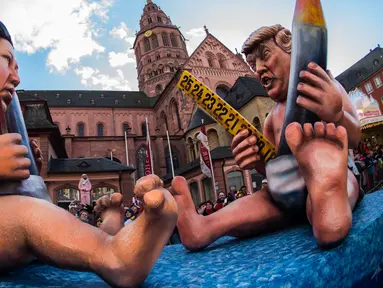 Kereta karnaval membawa karikatur tokoh kontroversial pemimpin Korea Utara, Kim Jong Un dan Presiden Amerika Serikat, Donald Trump dalam parade karnaval Rose Monday di Mainz, Jerman barat, Senin (12/2). (AFP PHOTO/dpa/Andreas Arnold/Germany OUT)