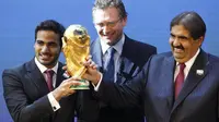 Mohamed bin Hamad Al-Thani, kiri, Ketua panitia lelang 2022, dan Sheikh Hamad bin Khalifa Al-Thani, Emir Qatar, memegang trofi Piala Dunia di depan Sekretaris Jenderal FIFA Jerome Valcke. (AP Photo/Anja Niedringhaus)