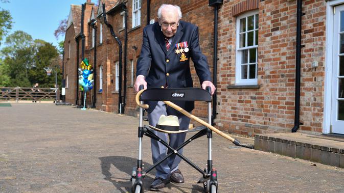 Veteran Perang Dunia II Kapten Tom Moore (99) berjalan di kebunnya di Marston Moretaine, London, 16 April 2020. Moore mengumpulkan donasi lebih dari 16 juta dolar untuk National Health Service (NHS) dengan berjalan 100 kali bolak-balik jarak 25 meter di taman belakang rumahnya. (Justin TALLIS/AFP)