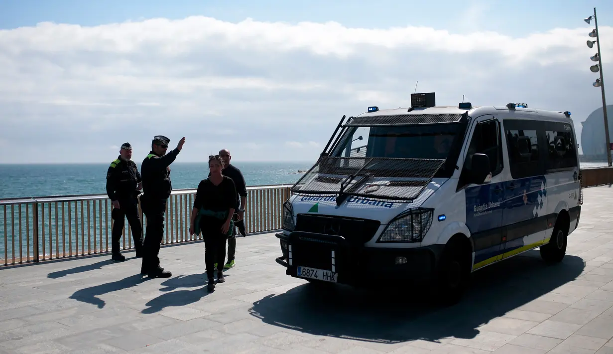 Polisi mencegah akses ke pantai di Barcelona, Spanyol, Minggu (15/3/2020). Spanyol saat ini memiliki 6.392 kasus virus corona COVID-19 dengan total kematian 197 orang dan 517 pasien sembuh. (AP Photo/Joan Mateu)