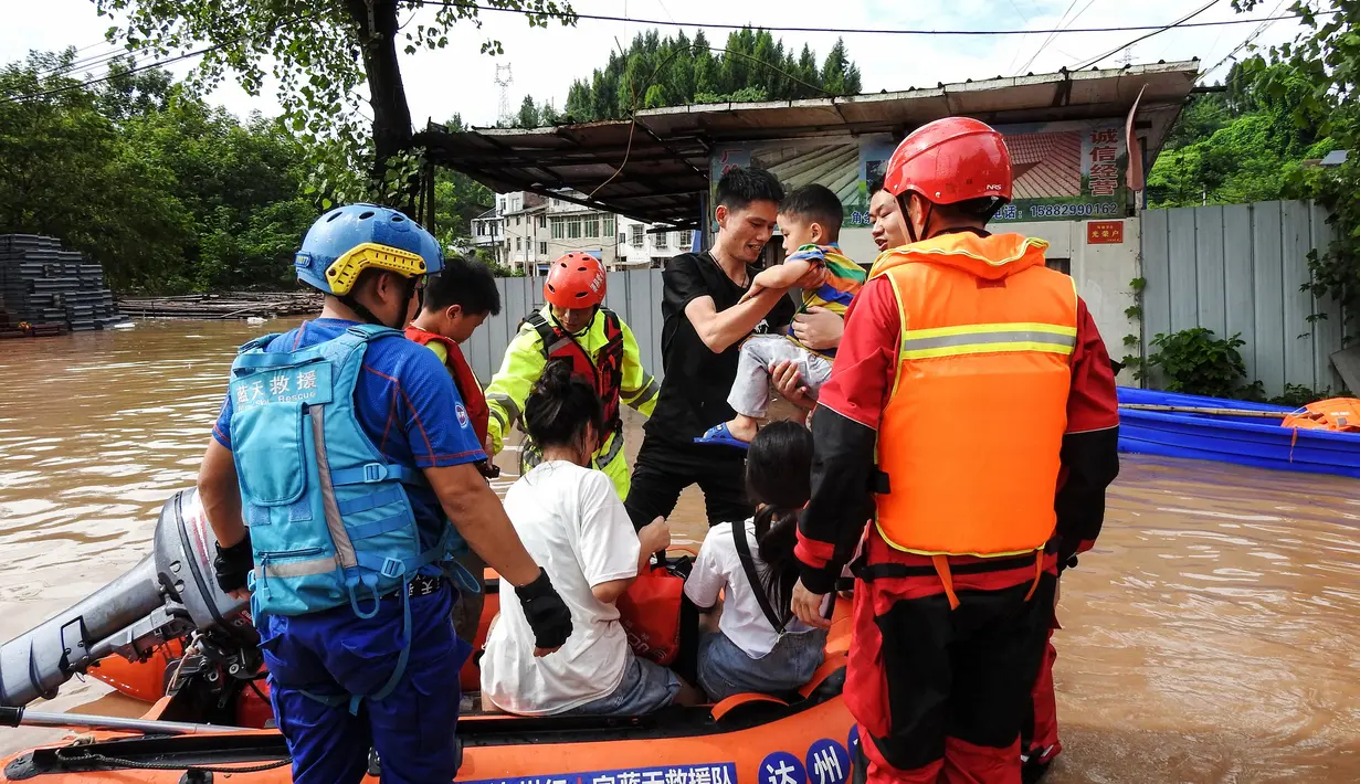 Tim SAR mengevakuasi penduduk yang terkena dampak banjir setelah hujan lebat di Dazhou, Sichuan, China, Minggu (11/7/2021). Banjir akibat hujan lebat melanda sejumlah wilayah di China. Ribuan orang terpaksa dievakuasi dan rumah-rumah mengalami pemadaman listrik akibat bencana tersebut. (AFP/STR)