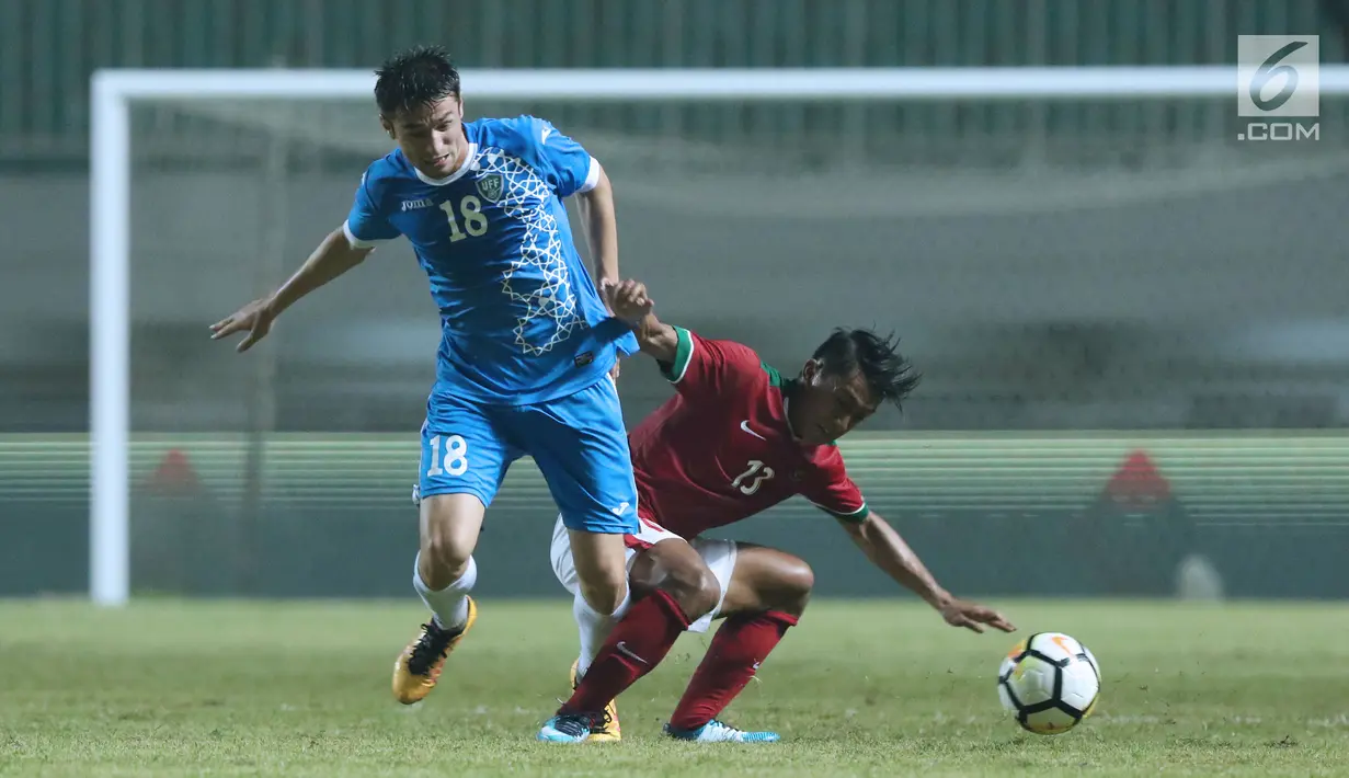 Pemain depan Indonesia U-23, Lerby Eliandry (kanan) berebut bola dengan pemain Uzbekistan, Alijanov Ilkhomijon pada laga PSSI Anniversary 2018 di Stadion Pakansari, Kab Bogor, Kamis (3/5). Laga berakhir imbang 0-0. (Liputan6.com/Helmi Fithriansyah)