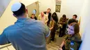 Anggota kelompok pers yang meliput Menteri Luar Negeri AS Antony Blinken berlindung di tangga di dalam Kirya, yang menampung Kementerian Pertahanan Israel, di Tel Aviv, Israel, Senin (16/10/2023). Sirene di Tel Aviv yang memperingatkan adanya roket yang masuk mendorong staf untuk berlindung di tangga saat Blinken bertemu dengan Menteri Pertahanan Israel. (AP Photo/Jacquelyn Martin, Pool)