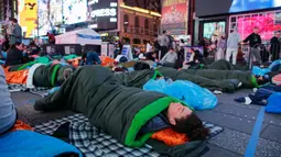 Para aktivis menggelar aksi dengan beralaskan kantong tidur. (KENA BETANCUR/AFP)