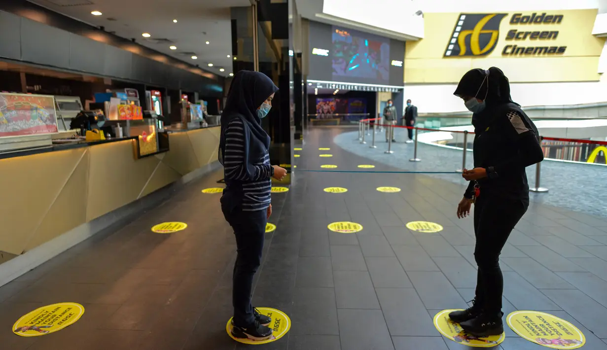 Para staf memasang penanda untuk mengingatkan pengunjung menjaga jarak sosial sebagai persiapan pembukaan kembali bioskop di Kuala Lumpur, Malaysia (26/6/2020). Pemerintah Malaysia mengizinkan bioskop dan teater untuk beroperasi kembali mulai 1 Juli mendatang. (Xinhua/Chong Voon Chung)