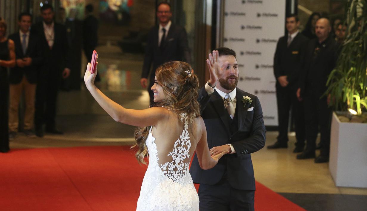 Bintang Barcelona, Lionel Messi, bersama sang istri, Antonella Roccuzzo, melabaikan tangan setelah menemui wartawan usai mengadakan resepsi pernikahan di Kompleks City Center, Santa Fe, Jumat (30/6/2017). (AP/Victor R Caivano)