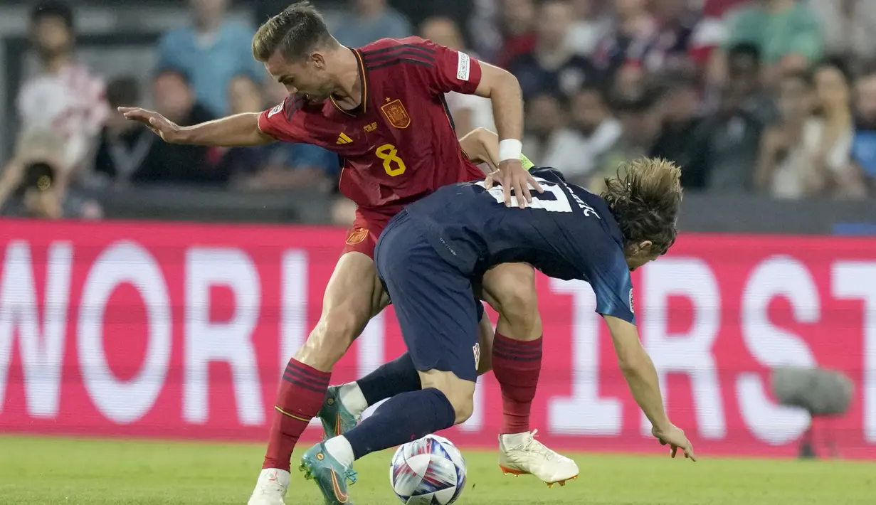 Gelandang Timnas Spanyol, Fabian Ruiz (kiri) berebut bola dengan gelandang Timnas Kroasia, Luka Modric pada laga final UEFA Nations League 2022/2023 di De Kuip Stadium, Rotterdam, Senin (19/6/2023) dini hari WIB. (AP Photo/Peter Dejong)