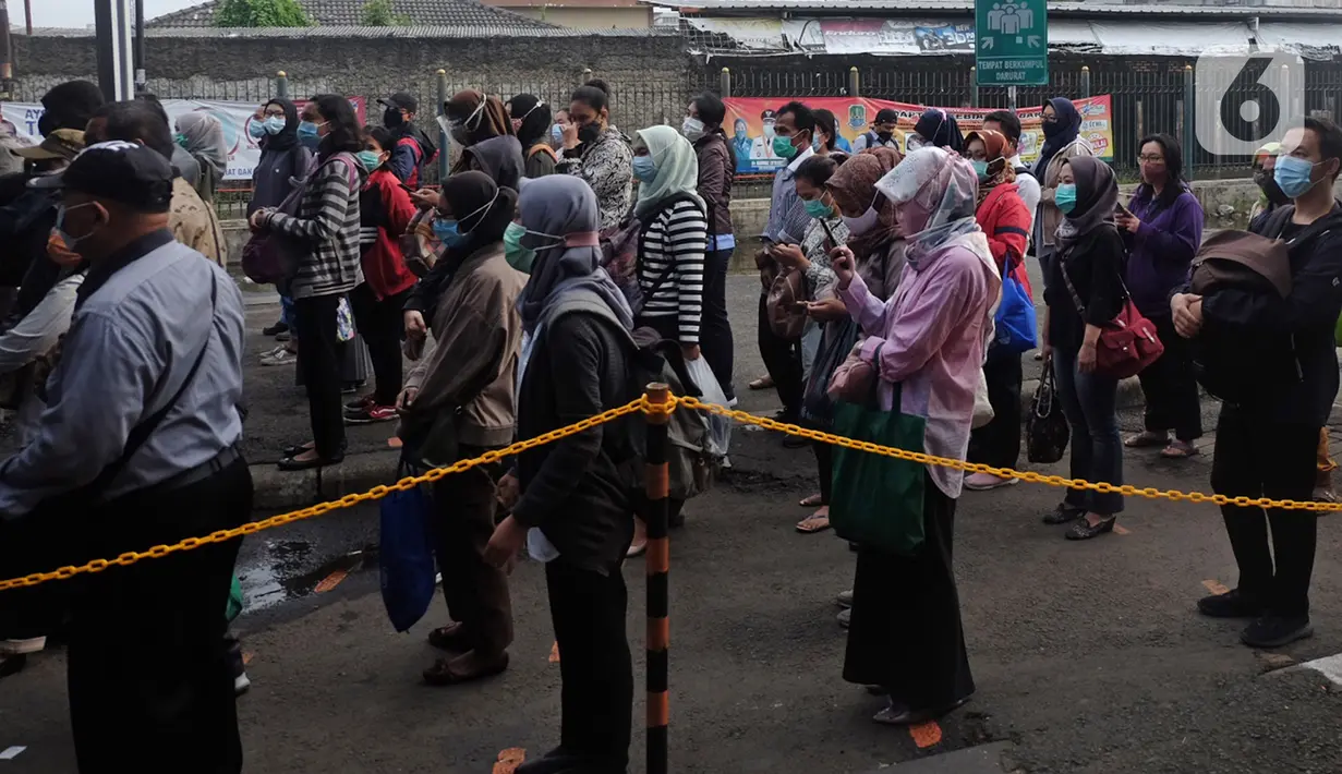 Calon penumpang KRL antre untuk masuk ke dalam Stasiun Bekasi, Jawa Barat, Senin (1/2/2021). Mereka mengantre dengan penjagaan ketat petugas keamanan Stasiun Bekasi. (Liputan6.com/Herman Zakharia)