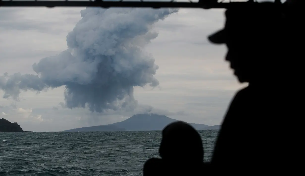 Personel TNI Angkatan Laut menyaksikan Gunung Anak Krakatau yang memuntahkan material vulkanik di perairan Selat Sunda (28/12). Pihak berwenang mengatakan pencarian korban terdampak tsunami akan berlanjut hingga Januari. (AP Photo/Fauzy Chaniago)