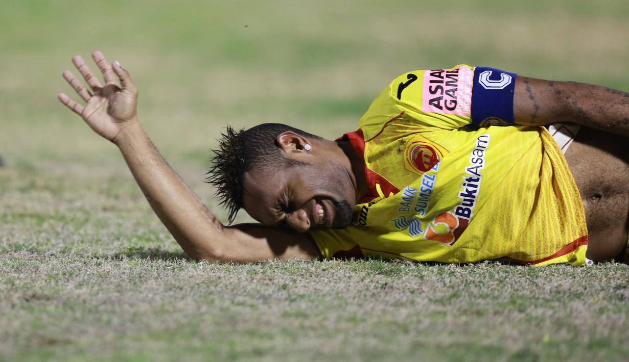 Pemain Sriwijaya FC Titus Bonai meringis kesakitan saat terjatuh  pada laga semifinal Piala Presiden di Stadion Manahan, Solo, Minggu (11/10/2015). Sriwijaya menang 2-1. (Bola.com/Nicklas Hanoatubun).