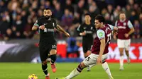 Striker Mesir Liverpool Mohamed Salah berlari dengan bola dari bek Yunani West Ham United Konstantinos Mavropanos selama pertandingan sepak bola Liga Primer Inggris antara West Ham United dan Liverpool di Stadion London, di London pada 29 Desember 2024.Adrian Dennis / AFP