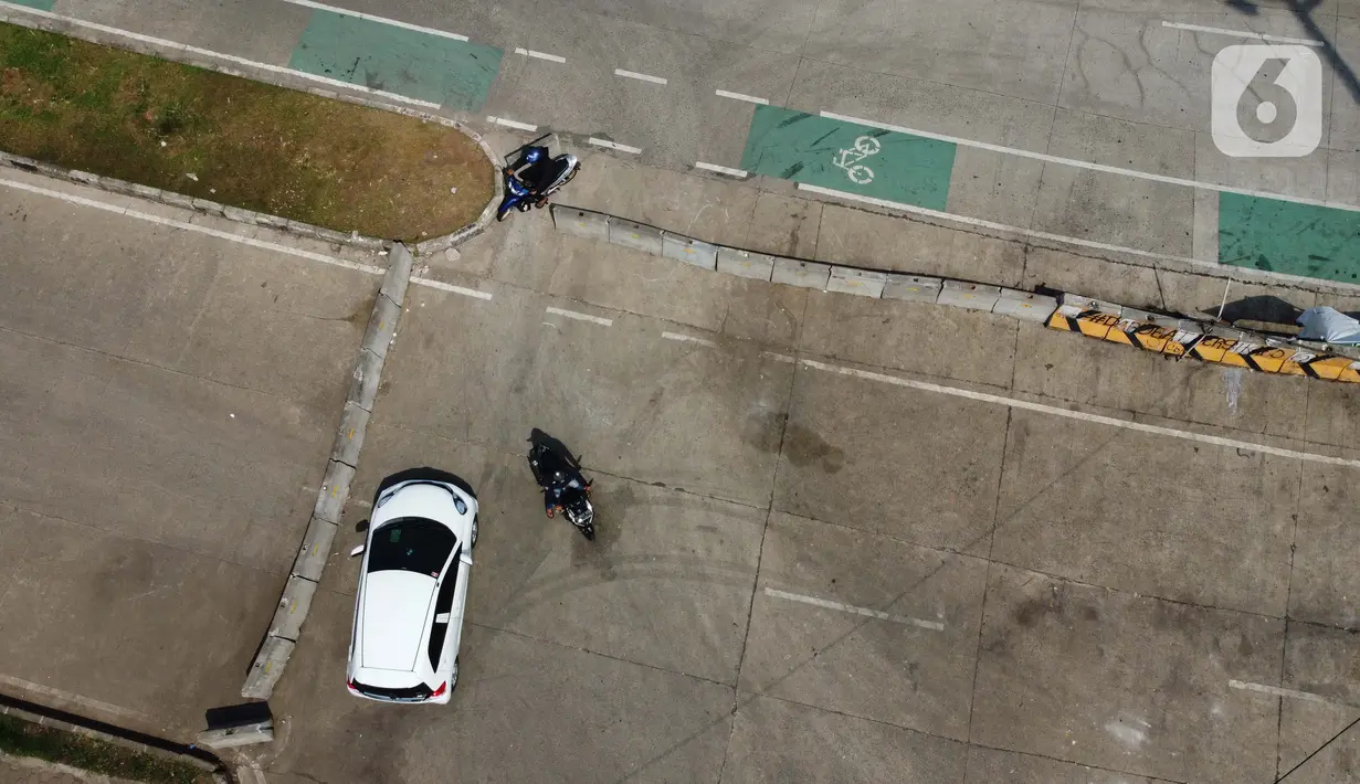 Pengendara motor menerobos beton pembatas di kawasan lingkar Stadion Pakansari, Kabupaten Bogor, Jawa Barat, Rabu (10/6/2020). Pemkab Bogor masih melakukan Pembatasan Sosial Berskala Besar (PSBB) secara proporsional hingga 2 Juli mendatang. (Liputan6.com/Helmi Fithriansyah)