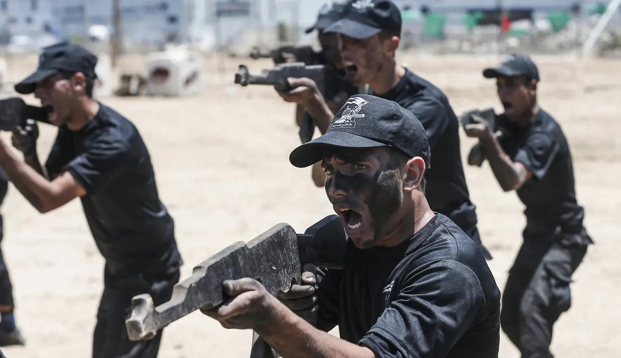 Sejumlah kadet Palestina berlatih menembak dengan militer Hamas, Brigade Ezzedin al-Qassam, di Kota Gaza (20/7/2019). Serangkaian tes militer pun harus dilakukan para kadet yang dimulai dari uji fisik, ketangkasan hingga menembak. (AFP Photo/Mahmud Hams)