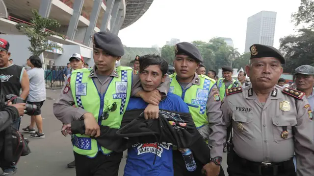 Polisi mengamankan seorang pria yang diduga sebagai provokator jelang laga final Piala Presiden 2015, Minggu (18/10/2015)