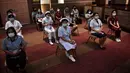 Petugas kesehatan menunggu untuk menerima vaksin Covid-19 CoronaVac dari Sinovac, di Institut Penyakit Menular Bamrasnaradura di Bangkok, Thailand, Minggu (28/2/2021). Tenaga medis dan relawan kesehatan menjadi golongan pertama yang menerima vaksin Covid-19 tersebut. (Lillian SUWANRUMPHA/AFP)