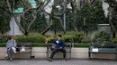 Orang-orang duduk di bangku dengan tanda untuk menjaga jarak di sebuah taman di Bangkok, Thailand pada Senin (4/1/2021). Pejabat kesehatan di Thailand pada Senin mencatat 745 kasus virus corona baru, rekor tertinggi harian di negara itu sejak dimulainya pandemi COVID-19. (Jack TAYLOR / AFP)