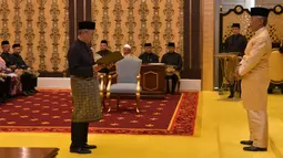Muhyiddin Yassin (kiri) menyatakan sumpah di depan Raja Sultan Abdullah Sultan Ahmad Shah (kanan) saat upacara pelantikannya sebagai PM Malaysia, Istana Negara, Kuala Lumpur, Minggu (1/3/2020). Muhyiddin Yassin menjadi PM ke-8 Malaysia. (MASZUANDI ADNAN/MALAYSIA'S DEPARTMENT OF INFORMATION/AFP)