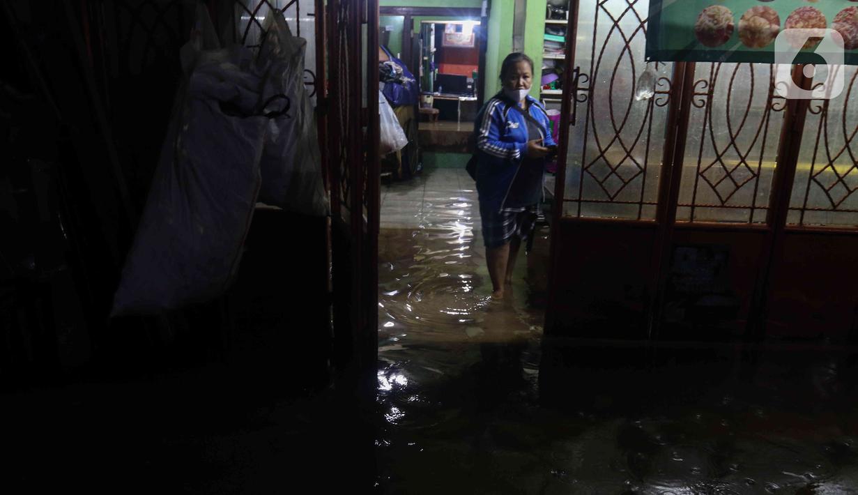 Seorang warga berdiri di tengah banjir yang melanda Jalan Bangka, Jakarta, Rabu (4/1/2023). Hujan deras yang terjadi pada Rabu sore membuat Kali Mampang meluap hingga menyebabkan banjir di kawasan tersebut dengan ketinggian bervariasi mulai dari 40 hingga 60 cm. (Liputan6.com/Herman Zakharia)