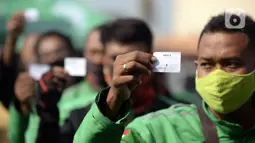 Pengemudi ojek online menunjukkan nomor antrean saat menjalani swab test COVID-19 di Alam Sutra, Tangerang Selatan, Banten, Selasa (21/7/2020). Swab test gratis tersebut digelar di tengah kasus COVID-19 yang terus bertambah di beberapa daerah di Indonesia. (merdeka.com/Dwi Narwoko)