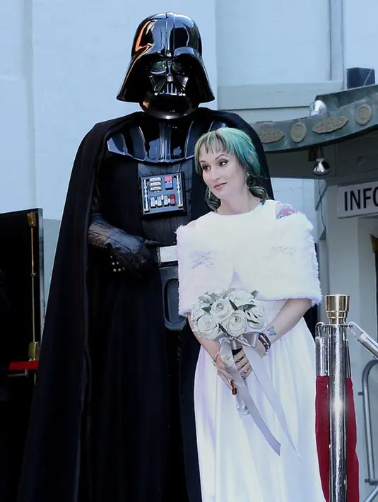Caroline berjalan ke altar bersama penggemar berbusana Darth Vader dan diiringi alunan musik "The Imperial March". Selain Lord Vader, ada pula robot R2-D2 dan Chewbacca menambah kemeriahan acara pernikahan kedua mempelai. (dailymail.co.uk)