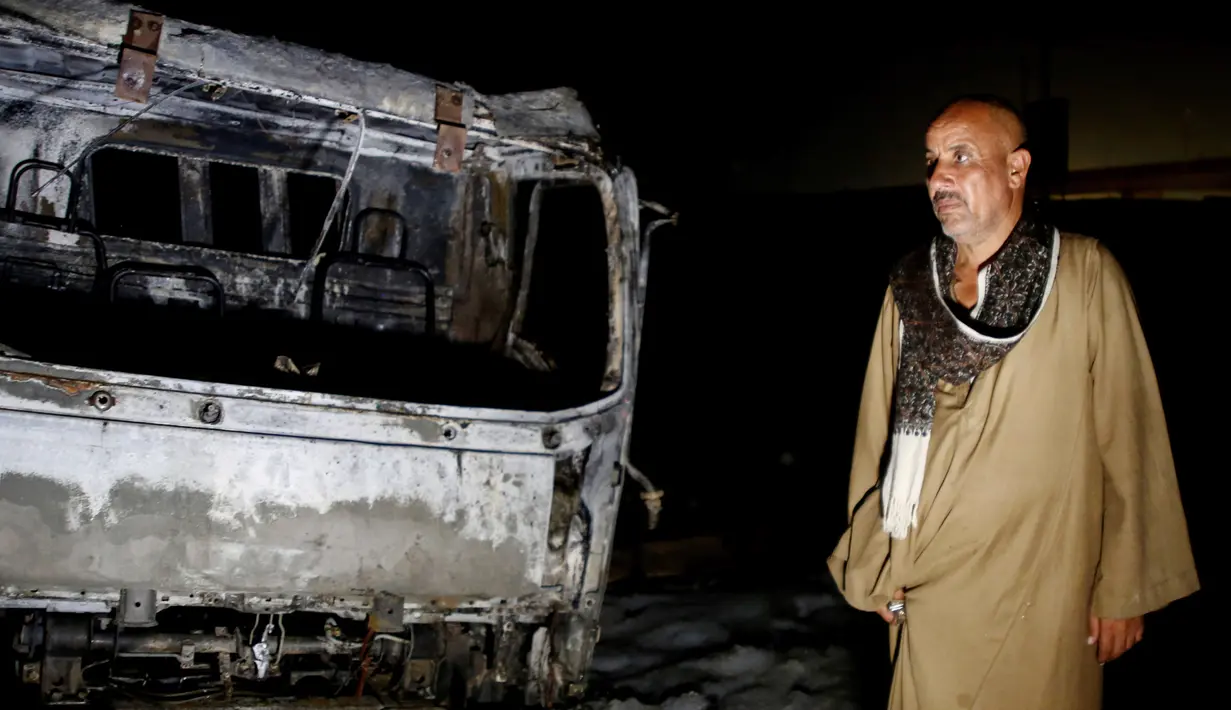 Seorang pria berdiri di samping mobil yang terbakar di lokasi kebakaran pipa minyak mentah di Kairo, ibu kota Mesir (14/7/2020). Sebanyak 17 orang terluka akibat insiden kebakaran pipa minyak mentah di Kairo, demikian disampaikan Kementerian Kesehatan Mesir. (AP Photo/Alaa Ahmed)