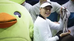 Maria Sharapova berpose dengan trofi setelah memenangkan pertandingan melawan Aryna Sabalenka di turnamen tenis Tianjin Open di Tianjin (15/10). ini merupakan gelar pertama Sharapova sejak kembali bertanding karena kasus doping. (AFP Photo/Wang Zhao)