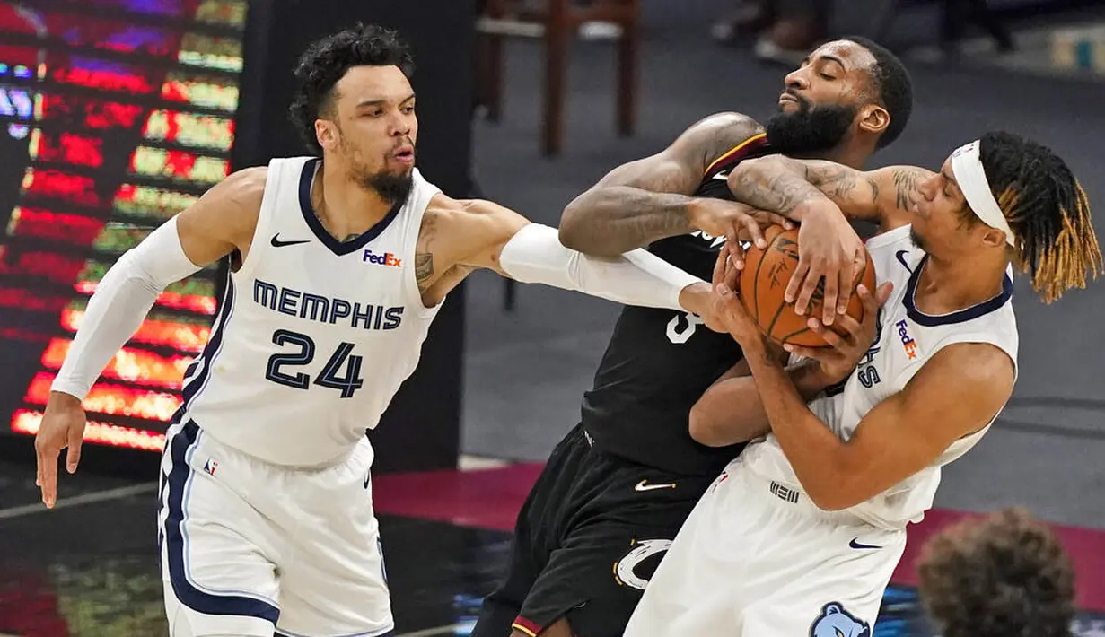 Pebasket Memphis Grizzlies, Dillon Brooks dan Brandon Clarke, berusaha merebut bola dari pebasket Cleveland Cavaliers, Andre Drummond, pada laga NBA, Senin (11/1/2021). Grizzlies menang dengan skor 101-91. (AP/Tony Dejak)