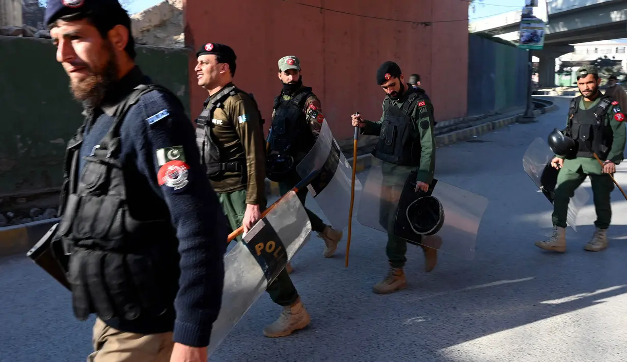 Polisi berpatroli di sepanjang jalan di Peshawar pada tanggal 9 Februari 2024, sehari setelah pemilihan umum nasional Pakistan. (Abdul MAJEED/AFP)
