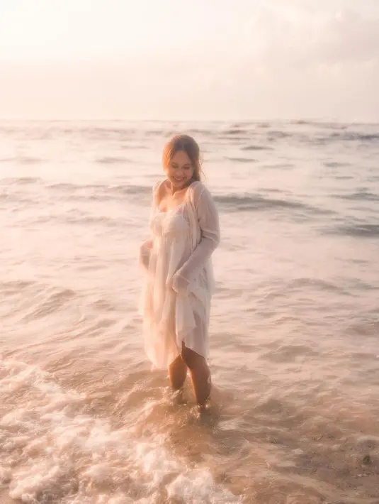 Tampil anggun ala Nadine Amizah yang mengenakan ruffle dress dan cardigan nuansa warna soft cream.   [Foto: IG/cakecaine ].