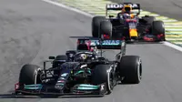 Pembalap Mercedes Lewis Hamilton (depan) mengemudikan mobilnya diikuti pembalap Red Bull Max Verstappen pada Formula 1 Grand Prix di Sirkuit Interlagos, Sao Paulo, Brasil, 14 November 2021. Lewis Hamilton di urutan pertama, Max Verstappen kedua, dan Valtteri Bottas ketiga. (AP Photo/Andre Penner)