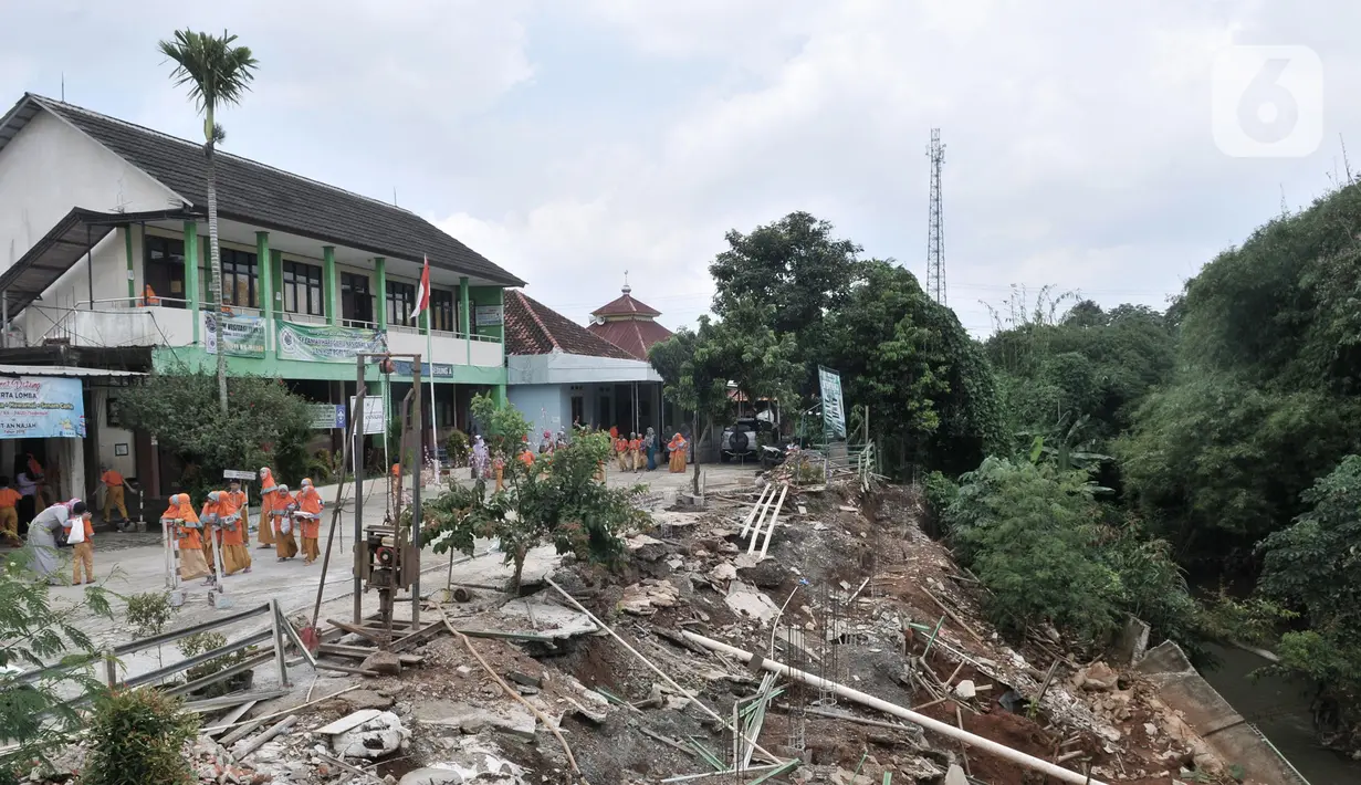 Siswa berjalan dekat lokasi tanah longsor di depan Gedung SDIT An-Najah, Kecamatan Cipayung, Kota Depok, Jawa Barat, Selasa (18/2/2020). Longsor mengakibatkan pagar sekolah ambruk dan kegiatan di lapangan terpaksa dihentikan karena mengancam keselamatan siswa. (merdeka.com/Iqbal Nugroho)