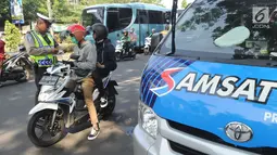 Petugas kepolisian memeriksa kelengkapan dokumen pengendara sepeda motor saat melakukan razia gabungan di kawasan Naggewer,  Bogor, Selasa (18/9). Razia itu menyasar pemilik kendaraan yang belum membayar pajak kendaraan. (Merdeka.com/Arie Basuki)