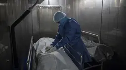Seorang petugas kesehatan mengisi kertas kerja untuk pasien yang meninggal karena COVID-19, di kamar mayat Rumah Sakit Samaritana di Bogota, Kamis (3/6/2021). Kolombia menjadi hotspot pandemi yang mengalami gelombang ketiga infeksi COVID-19 dan lonjakan kematian. (AP Photo/Ivan Valencia)