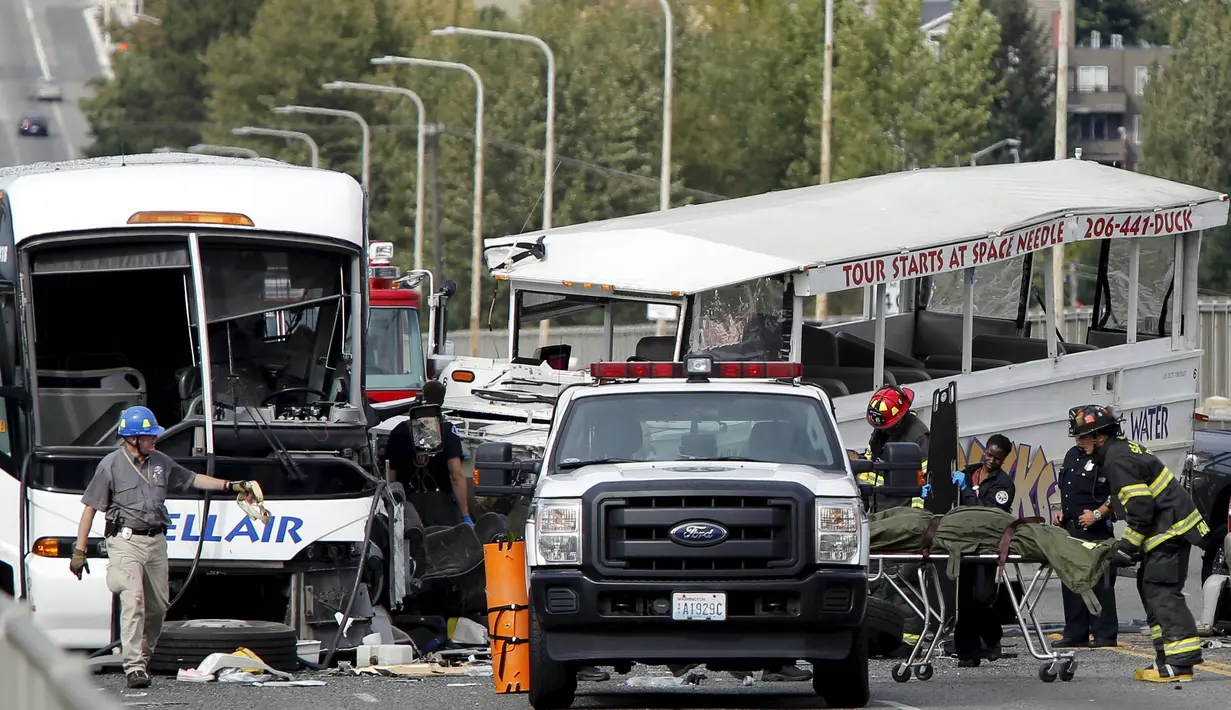 Petugas saat mengevakusi korban kecelakaan antara bus carter mahasiswa dengan kendaraan wisata amfibi di sebuah jembatan di Seattle, AS, Kamis (25/9). Kecelakaan itu menewaskan satu WNI bernama Privando Eduardus Putradanto. (REUTERS/Jason Redmond)