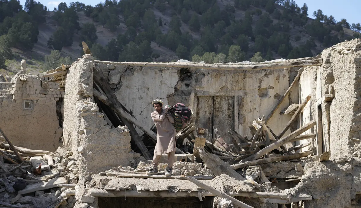 Seorang pria mengambil barang-barang setelah gempa bumi di desa Gayan, di provinsi Paktika, Afghanistan, Jumat, 24 Juni 2022. Gempa bumi yang menewaskan sedikitnya 1.000 orang, termasuk salah satu gempa paling mematikan di negara itu dalam dua dekade terakhir. (AP Photo/Ebrahim Nooroozi)