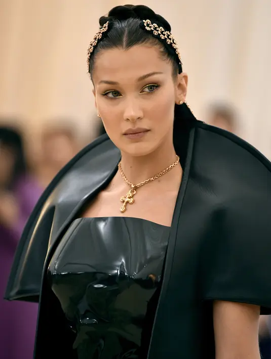 Ekspresi Bella Hadid saat menghadiri Met Gala 2018 di Metropolitan Museum of Art, New York (7/5). Bella tampil cantik dalam balutan korset lateks mengkilap oleh Chrome Hearts Official, dengan tombak sculptural. (AP Photo/Evan Agostini)