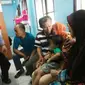 Rohana, istri sopir taksi online Palembang yang dibunuh secara sadis, menangis sedih disamping salah satu keluarganya (Liputan6.com / Nefri Inge)