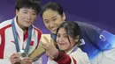 (Dari kanan) pebulu tangkis Indonesia peraih medali perunggu, Gregoria Mariska Tunjung, peraih medali emas An Se-young (Korea Selatan) dan peraih medali perak He Bing Jiao (Indonesia) berswafoto di atas podium saat upacara penyerahan medali nomor tunggal putri cabor bulu tangkis Olimpiade Paris 2024 di Porte de La Chapelle Arena, Paris, Senin (5/8/2024). (AP Photo/Dita Alangkara)