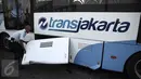 Petugas melihat kondisi bus transjakarta setelah ditabrak kereta Senja Utama Solo di perlintasan Jalan Mangga Dua, Jakarta, Kamis (19/5). Menurut keterangan, insiden itu disebabkan bus Transjakarta yang menerobos palang pintu. (Liputan6.com/Faizal Fanani)