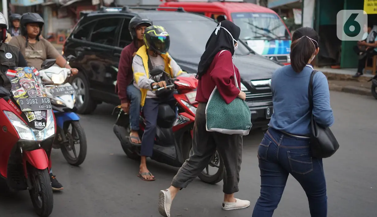 Pejalan kaki menyeberangi jalan di depan Stasiun Lenteng Agung, Jakarta, Senin (4/11/2019). Meski telah tersedia JPO, sebagian pejalan kaki lebih memilih untuk menyeberang sembarangan sehingga mengganggu arus lalu lintas serta berpotensi menimbulkan kecelakaan. (Liputan6.com/Immanuel Antonius)