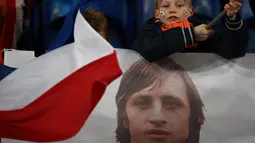 Suporter cilik Belanda dengan spanduk bergambar legenda sepak bola dunia, Johan Cruyff, dalam pertandingan antara Belanda melawan Prancis di Stadion Amsterdam Arena, (25/3/2016). Cruyff meninggal dunia dalam usia 68 tahun. (AFP/Franck Fife)