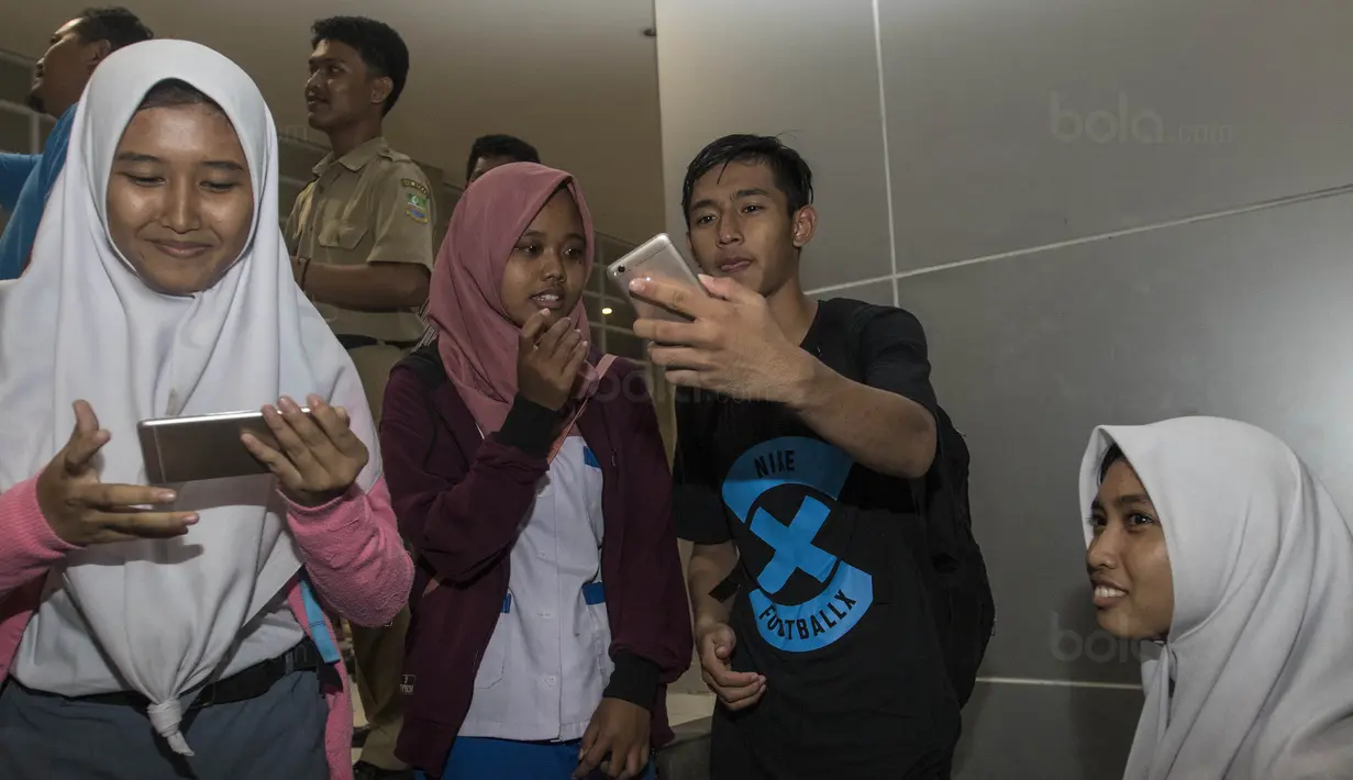 Striker Timnas Indonesia U-19, Hanis Saghara, selfie bersama fans usai latihan di Stadion Wibawa Mukti, Bekasi, Senin (16/10//2017). Kehadiran fans dengan senang hati disambut pemain Timnas U-19. (Bola.com/Vitalis Yogi Trisna)