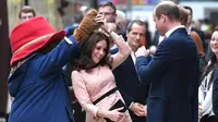 Berikut cantiknya Kate Middleton dalam balutan baju hamil bernuansa pink saat berdansa dengan maskot Paddington. (Chris J Ratcliffe/AFP)