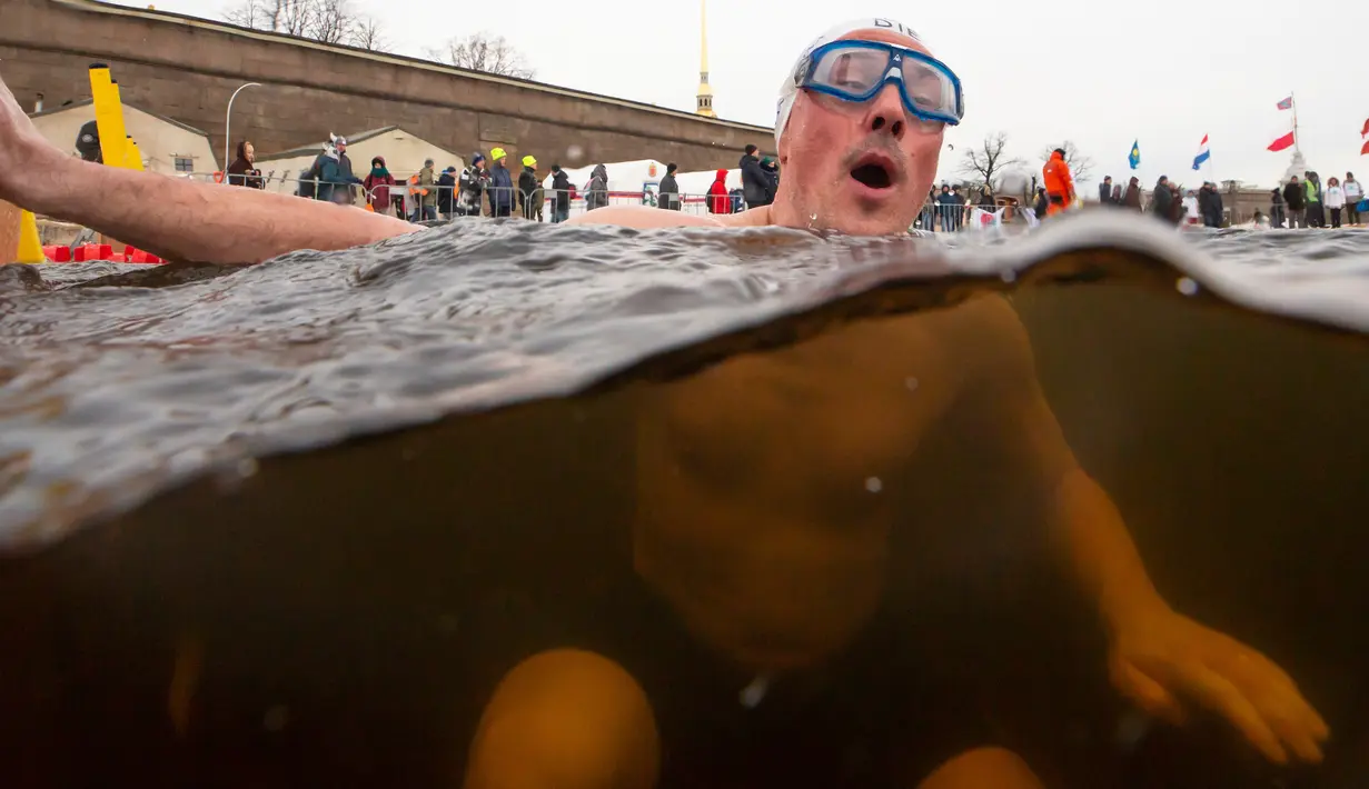 Ekspresi peserta saat mengikuti kompetisi renang di air es dari sungai Neva selama Big Neva Cup of Ice Swimming di St.Petersburg, Rusia, 2 Maret 2019. Sekitar 150 dari 12 negara ambil bagian kompetisi renang dengan suhu - 6 Celcius. (AP/Dmitri Lovetsky)