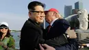 Kim Jong-un KW bernama Howard X dan Donald Trump KW, Dennis Alan berpelukan saat bertemu di Merlion Park, Singapura (8/6). Duo peniru itu melakukan aksi publisitas menjelang KTT Korea Utara - Amerika Serikat. (AP/Wong Maye-E)