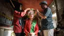 Seorang perempuan dengan pakaian tradisional dibantu menyiapkan hiasan bunga di rambutnya untuk berpartisipasi dalam Festival Ngarot di Lelea, Indramayu , Jawa Barat, pada 13 Desember 2023. (Timur MATAHARI/AFP)