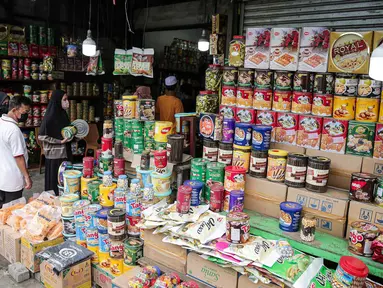 Calon pembeli memilih kue kering dalam kemasan di lapak penjual kue musiman di Jalan Raya Bogor Km. 26, Jakarta, Sabtu (30/4/2022). Menurut pedagang penjualan kue kering kemasan di kawasan itu meningkat menjelang Lebaran. (Liputan6.com/Faizal Fanani)