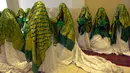 Pengantin menunggu dimulainya upacara pernikahan massal di Kabul, Afghanistan, 13 Juni 2022. Puluhan wanita Afghanistan yang disembunyikan dalam selendang hijau tebal dinikahkan dalam pernikahan massal yang ketat di Kabul. (Sahel ARMAN/AFP)